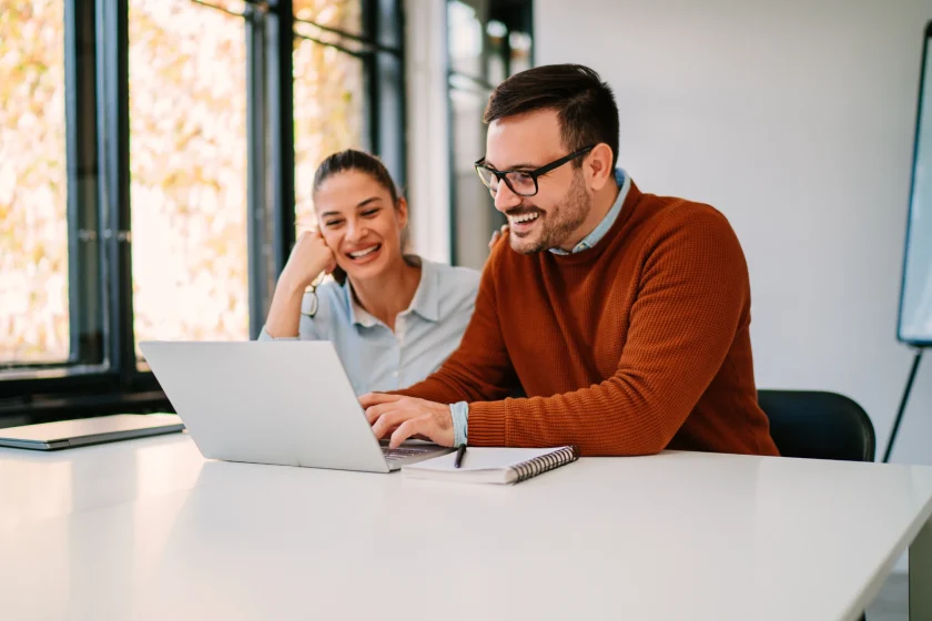 AI workflow automation with two professionals collaborating on a laptop in a modern office