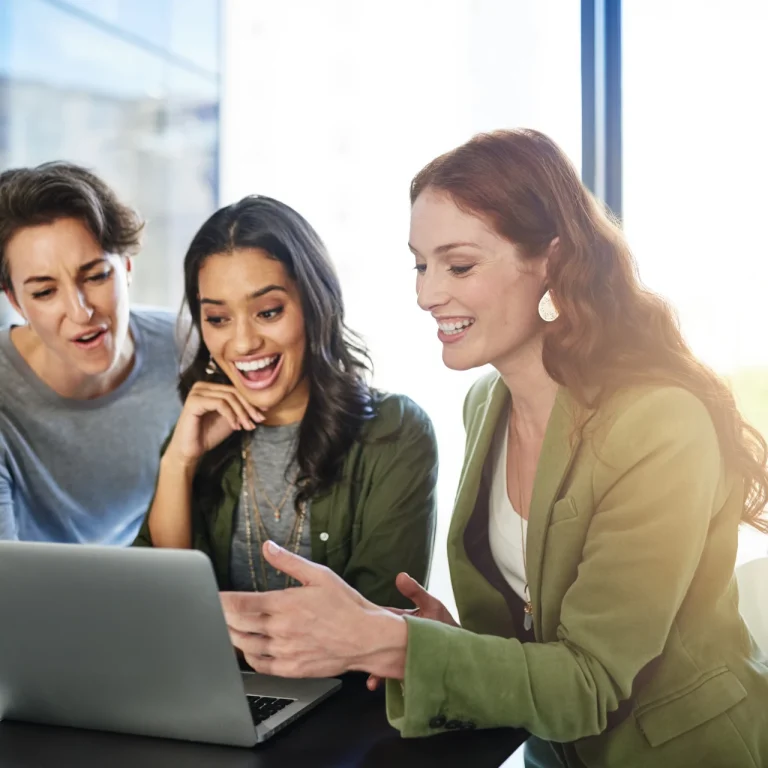 IT and technology business team reviewing project results and collaborating on a laptop during a strategy meeting.