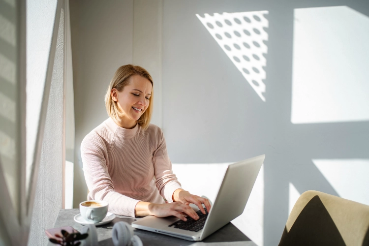 Person working on a laptop while preparing blog content for publishing